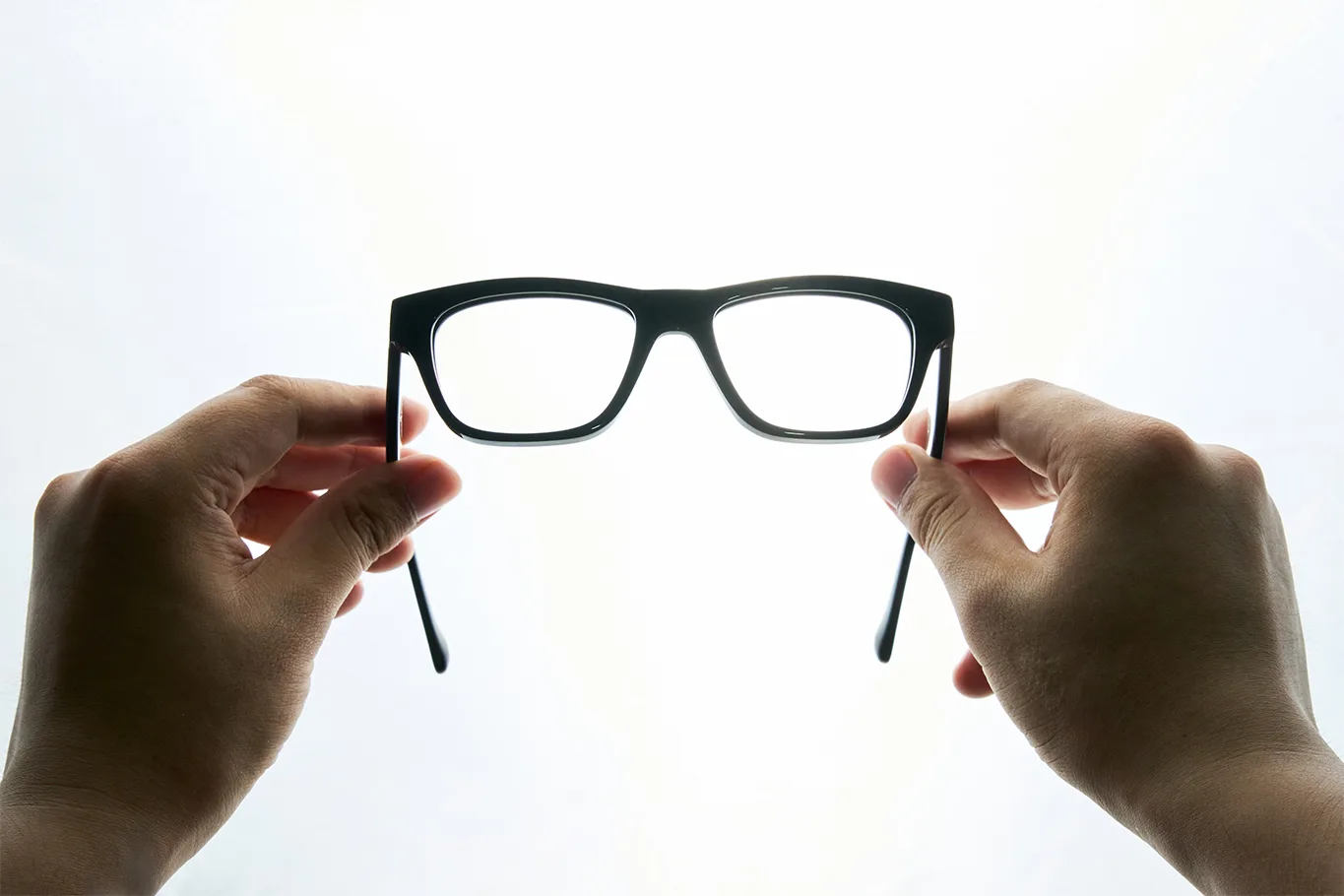 Hands evaluating the proportions of an optical frame